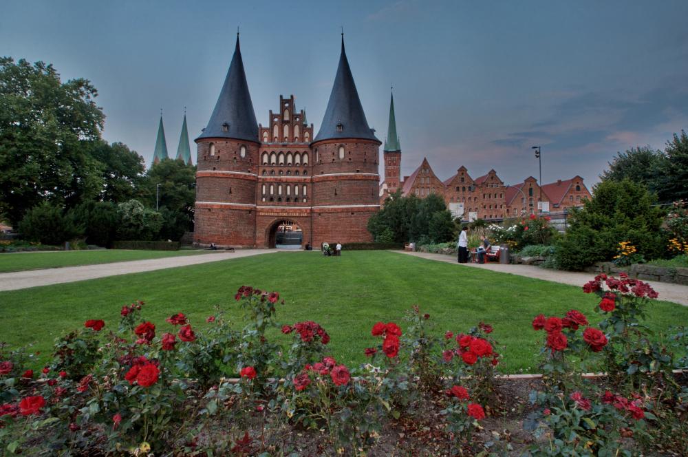 Das Holstentor in Lübeck mit blühenden Rosen davor